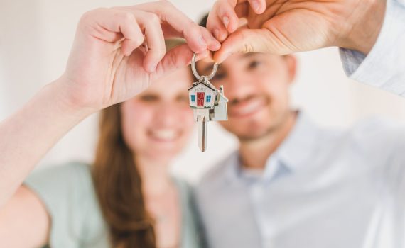 happy couple holding and showing a house key